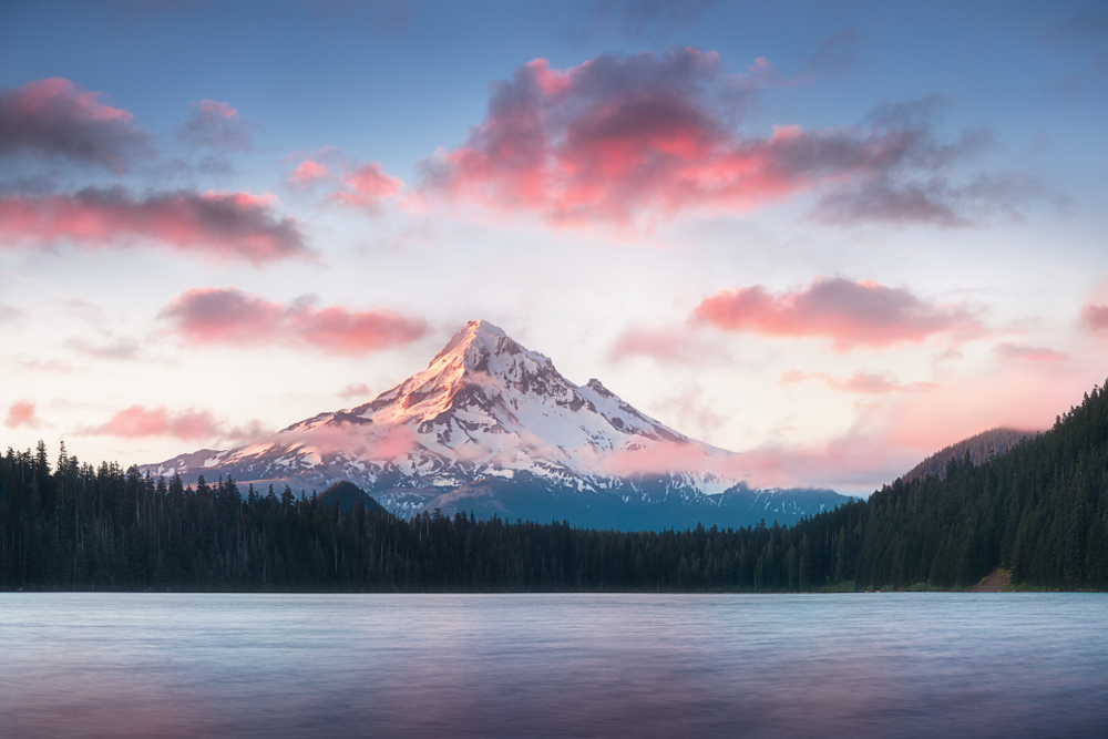 Pink sunset over Mount Hood with a lake in the foreground during an Oregon road trip.