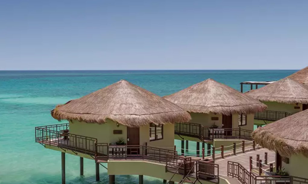 An overhead view of several overwater bungalows near the usa in mexico standing in clear blue water