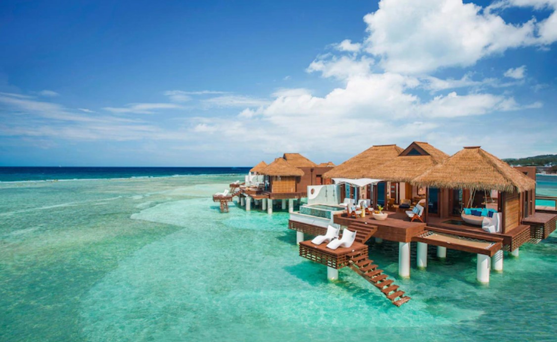 Several overwater bungalows near the usa looking out onto crystal blue ocean waters