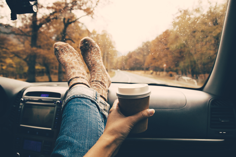 An article about general road trip questions. Picture is a girl with her feet on the dashboard.