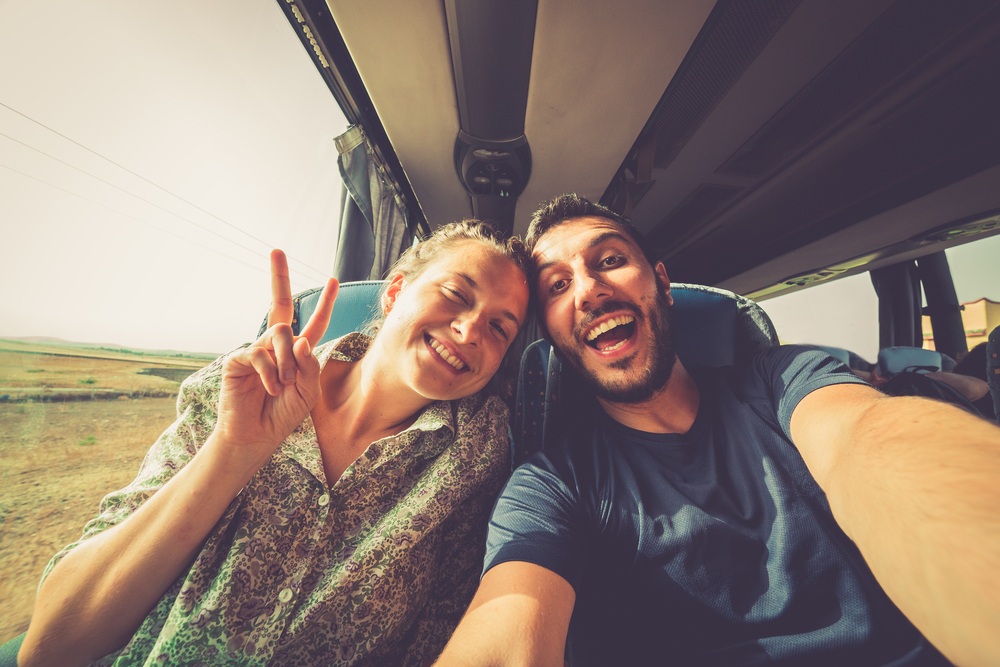 An article about travel road trip questions, picture is two young people on a bus