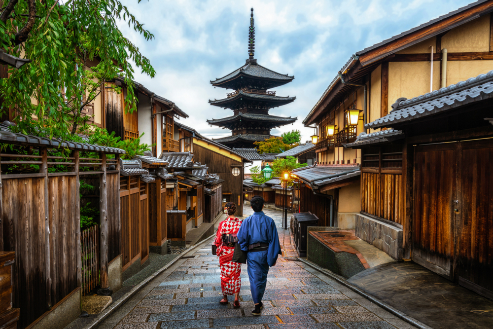  Asian traveler wearing traditional Japanese kimono walking in Higashiyama district in the old town of Kyoto, Japan.