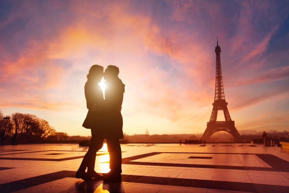 Paris, couple in love kissing near Eiffel tower, France. It is at sunset. Paris is one of the best vacation spots for couples. 