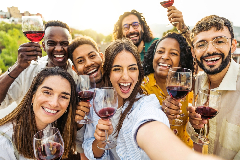 A group of friends cheersing to the camera with their wine glasses enjoying a tasting at a wonderful winery in Napa Valley, California, a fun 30th birthday celebration. 