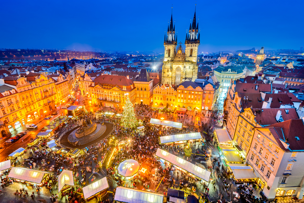 An arial shot of Prague shows the bustle of crowds in the town square during its traditional Christmas market. 