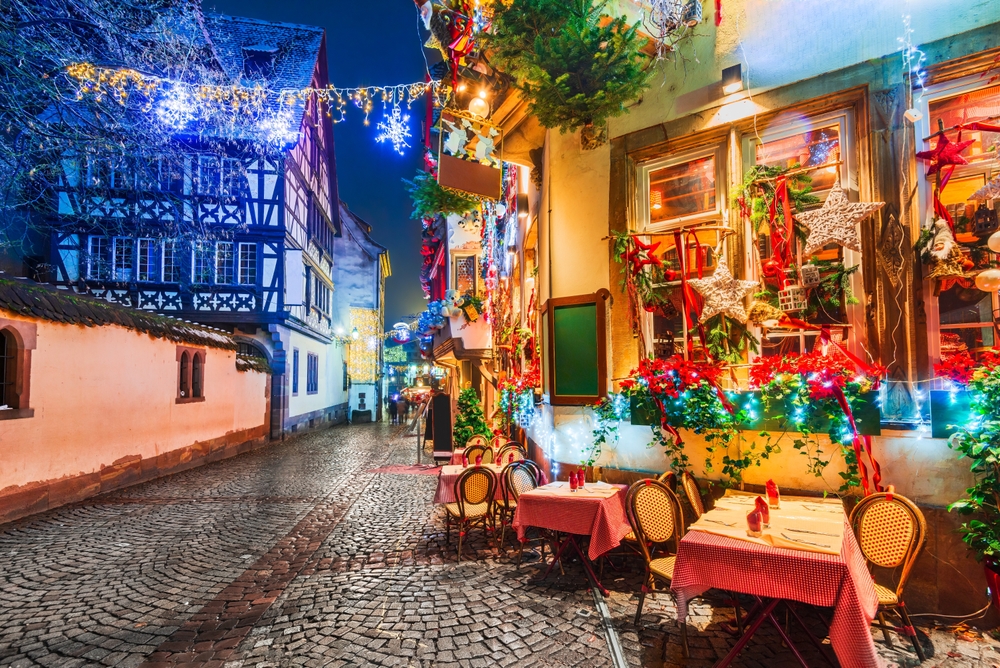 Strasbourg, one of the best Christmas cities in Europe, decorates everywhere: this photo shows a local cafe and its seats outside that are dawned with bows and lights and all things festive. 