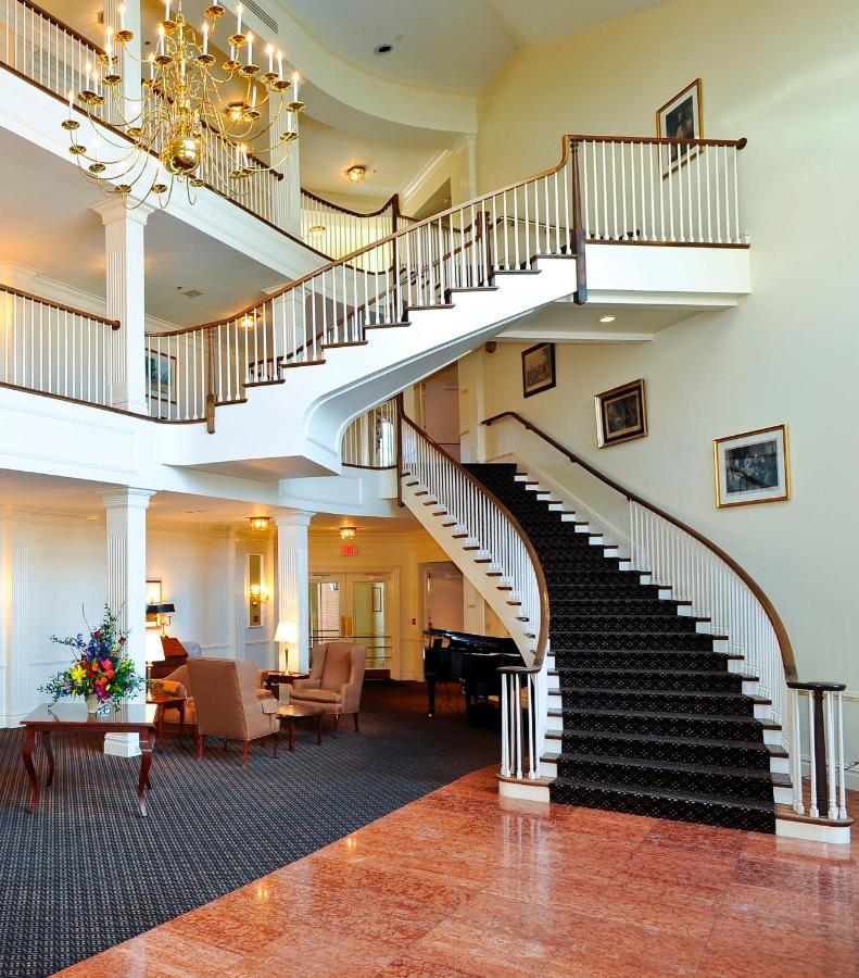 A winding, grad staircase with gold accents sits in the lobby of the Avon Old Farms Hotel, which is a great place to stay during a Connecticut fall foliage road trip.