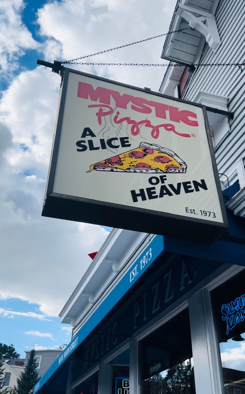 A close up shot of the Mystic Pizza sign-- yes inspired by the movie starring Julia Roberts-- reads "A slice of Heaven." 