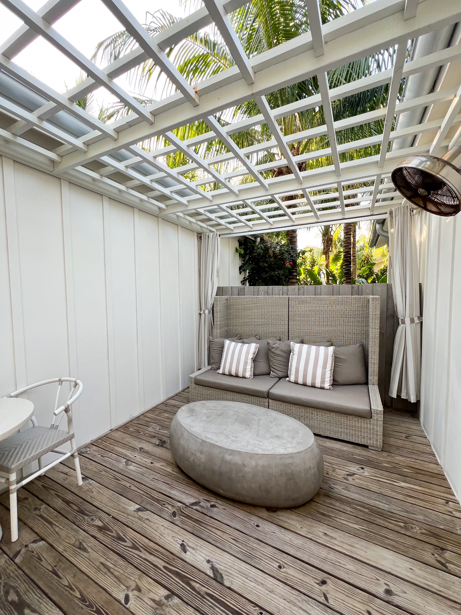 the outdoor private patio with a couch fan and open roof