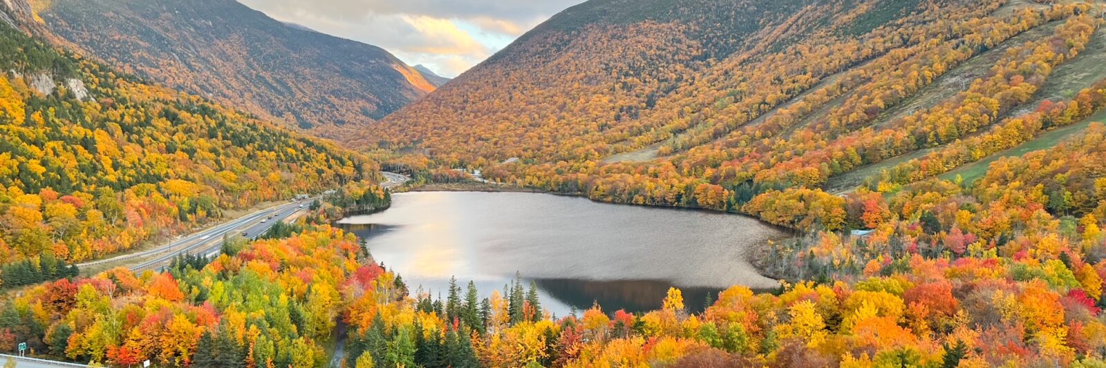 beautiful orange fall foliage in new england from above with a lake