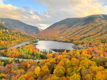 beautiful orange fall foliage in new england from above with a lake