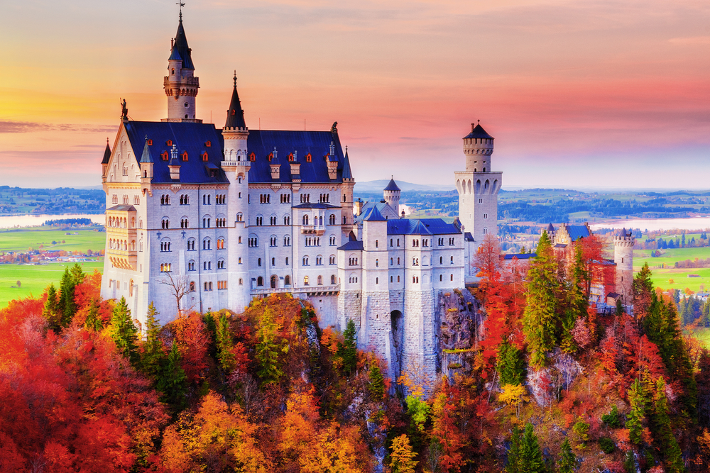 Germany. Famous Neuschwanstein Castle in the background of trees with yellow and green leaves and valley