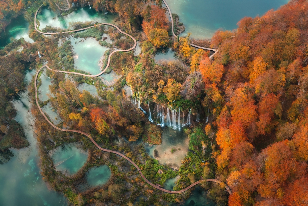 Autumn In Europe - Aerial view beautiful colorful majestic waterfall in national park autumn forest top view, Plitvice lakes, Slovenia. 