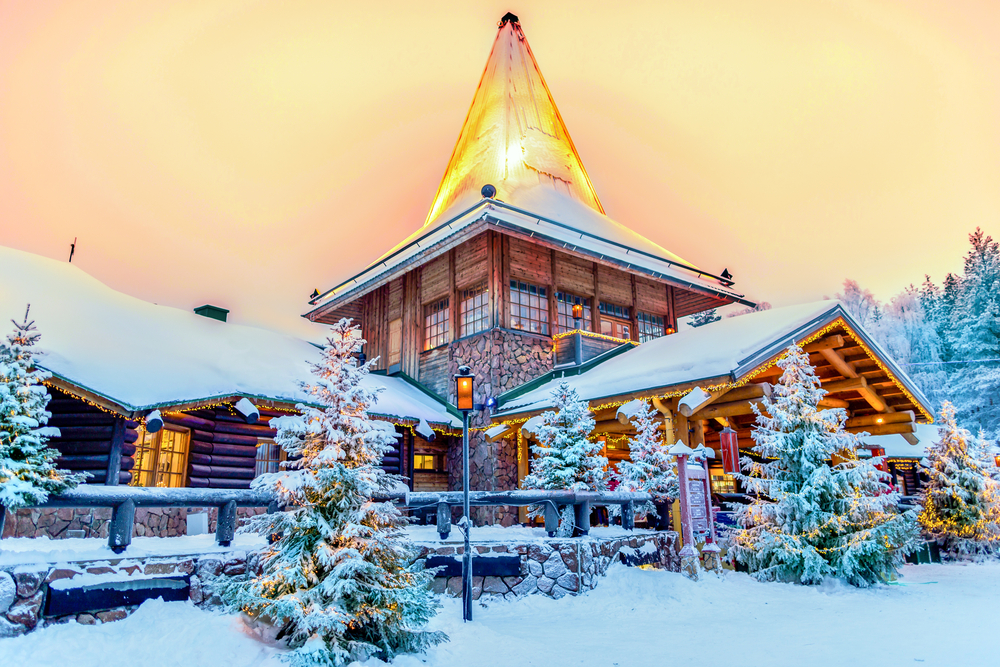 A snow capped lodge has a pointy top and fir trees surrounding it: this is known as Santa's place, because Rovaniemi is the official hometown of Santa, and therefore is one of the best Christmas towns in Europe.