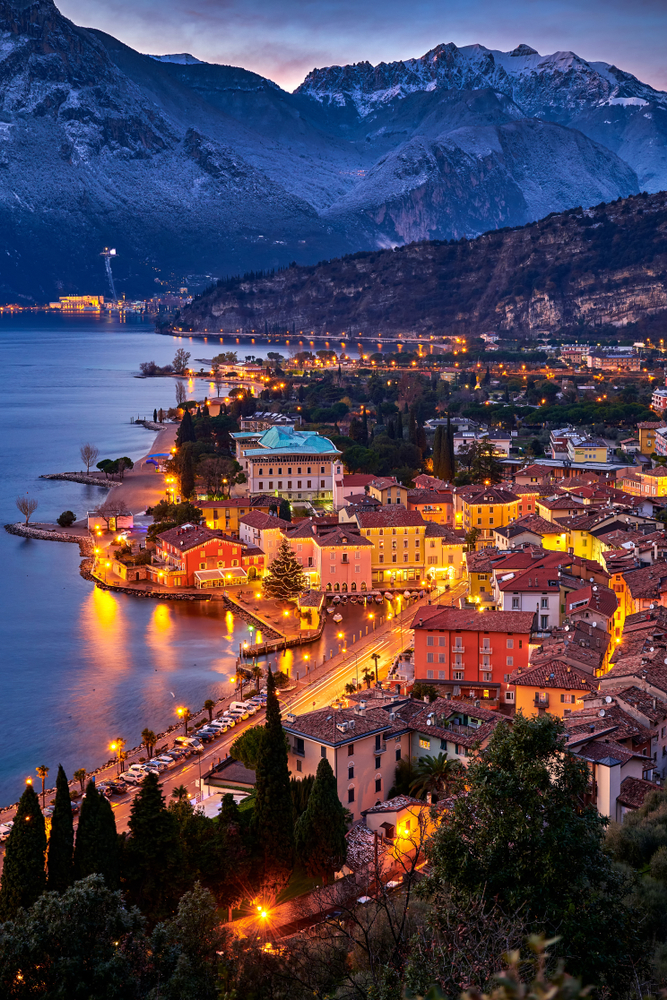 Nago-Torbole is another one of the best Christmas towns in Europe: this photo shows the lights of the town aglow with snowy mountains in the background. 