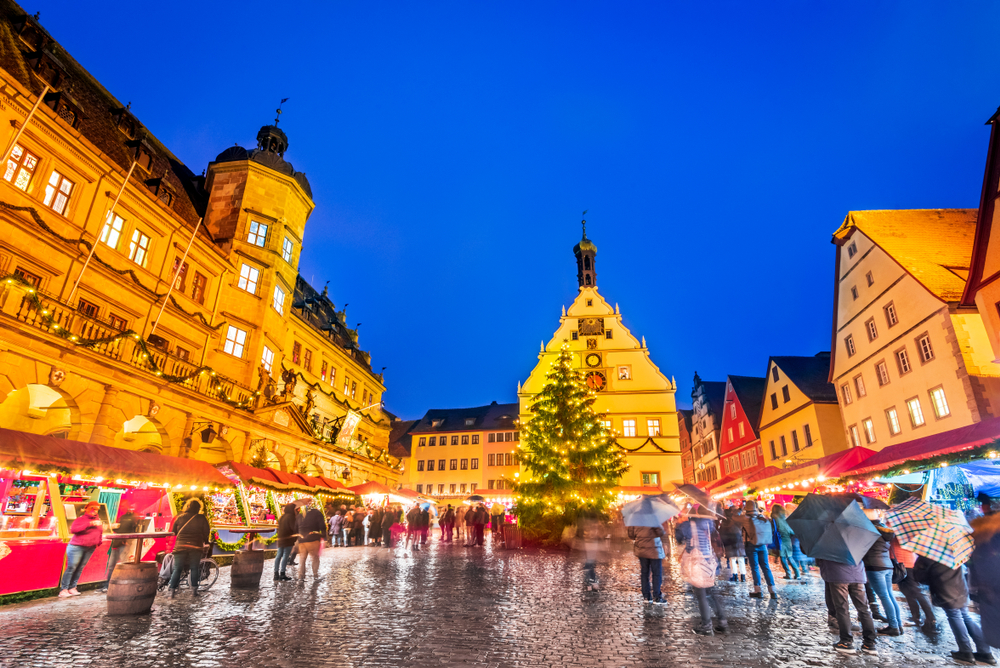 The best Christmas towns in Europe aren't hard to find: most show Christmas markets as seen in this photo, with wooden chalets, tons of people walking, and  a town square aglow with festive lights. 