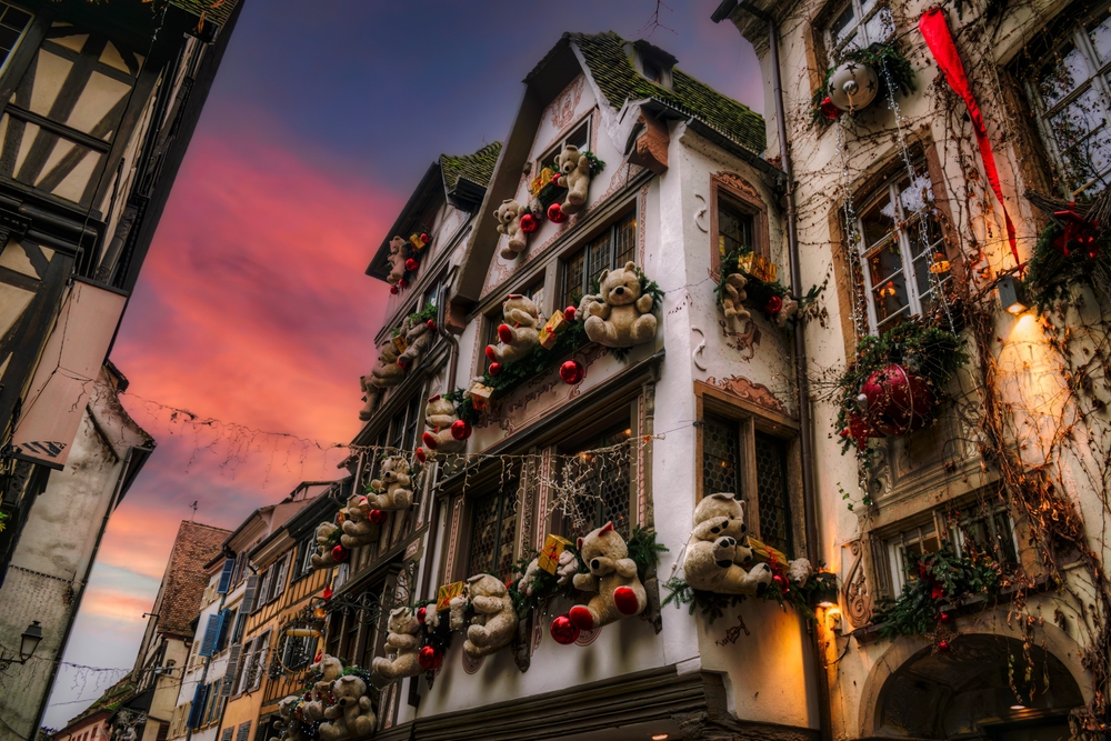 A low angle shot of Strasbourg shows why it is one of the best Christmas towns in Europe: the decor on buildings feature hanging lights, teddy bears, ribbons and more. 