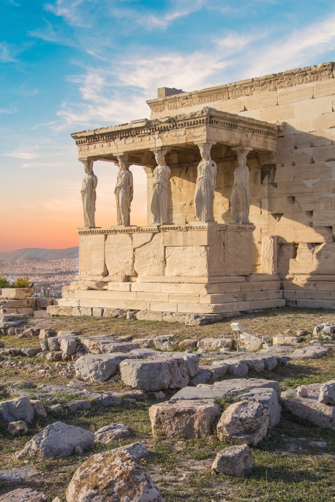 the acropolis in greece with its human shaped columns and large stones, sunrise in the background 