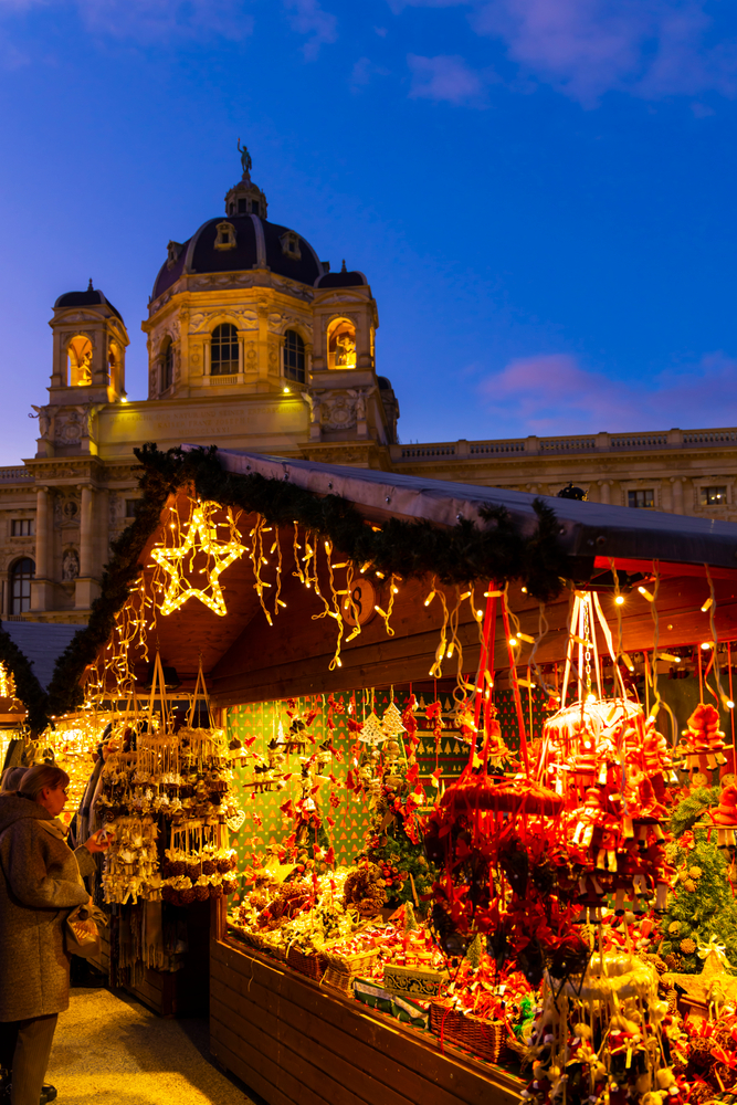 a shop selling christmas ornaments at  a christmas market in europe in the late evening 