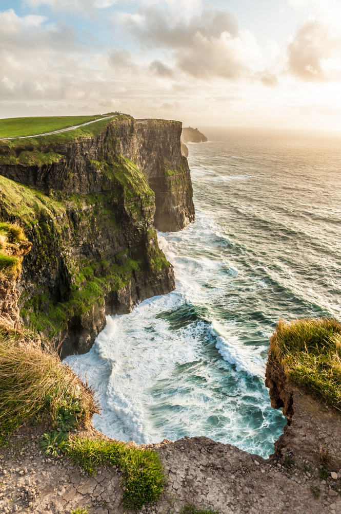 cliffs of moher on the left and the sea on the right at sunset in ireland 