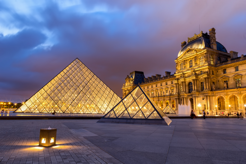 two glass triangle in front of the louvre museum in paris france on a cloudy evening 