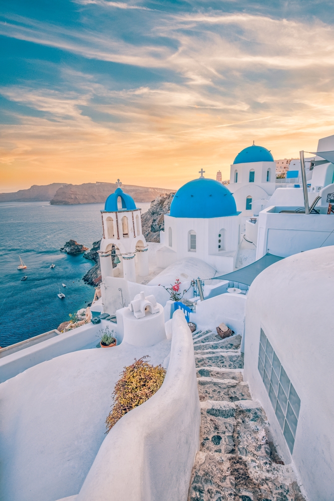 oia village in santorini, one of the best places in europe, water to the left and dome roofed buildings on the right 