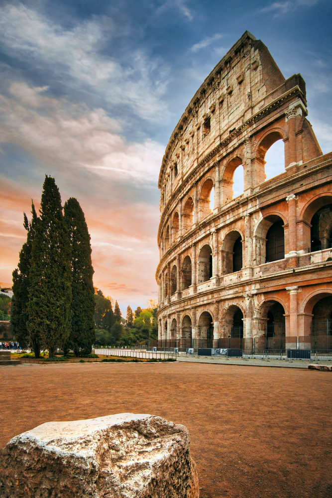 colosseum on the right, trees on the left, photo taken at sunset 