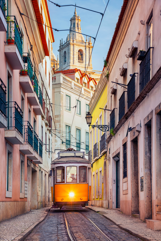 a tram is going down the street in lisbon portugal, one of the best things to do in europe 