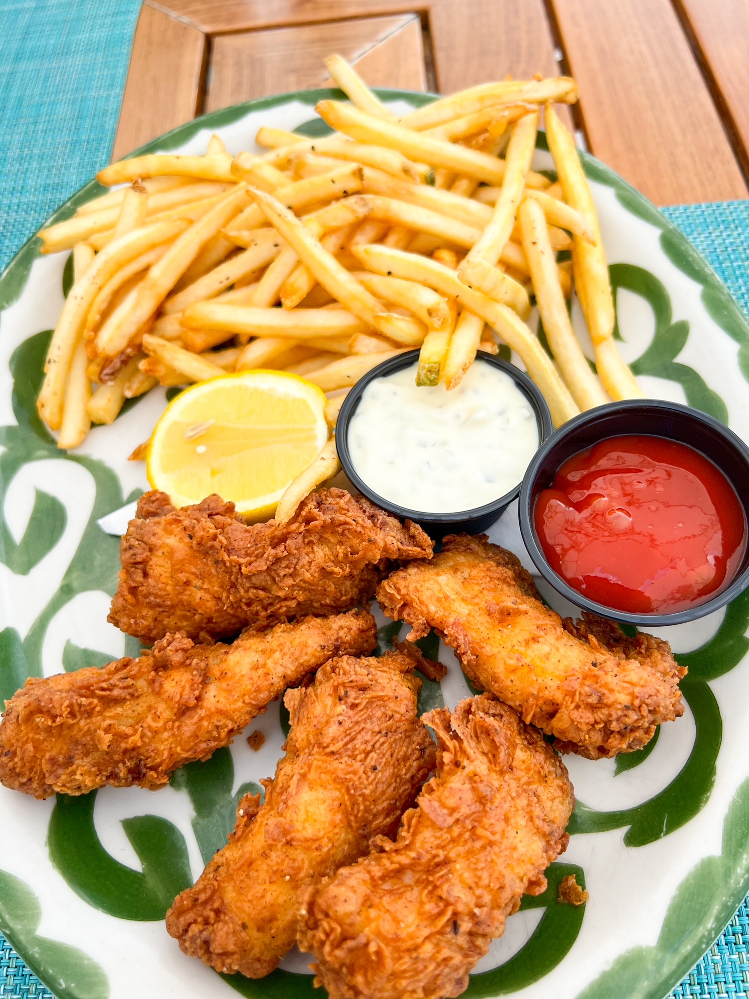 a plate of chicken and fries for a lunch at th tiki bar