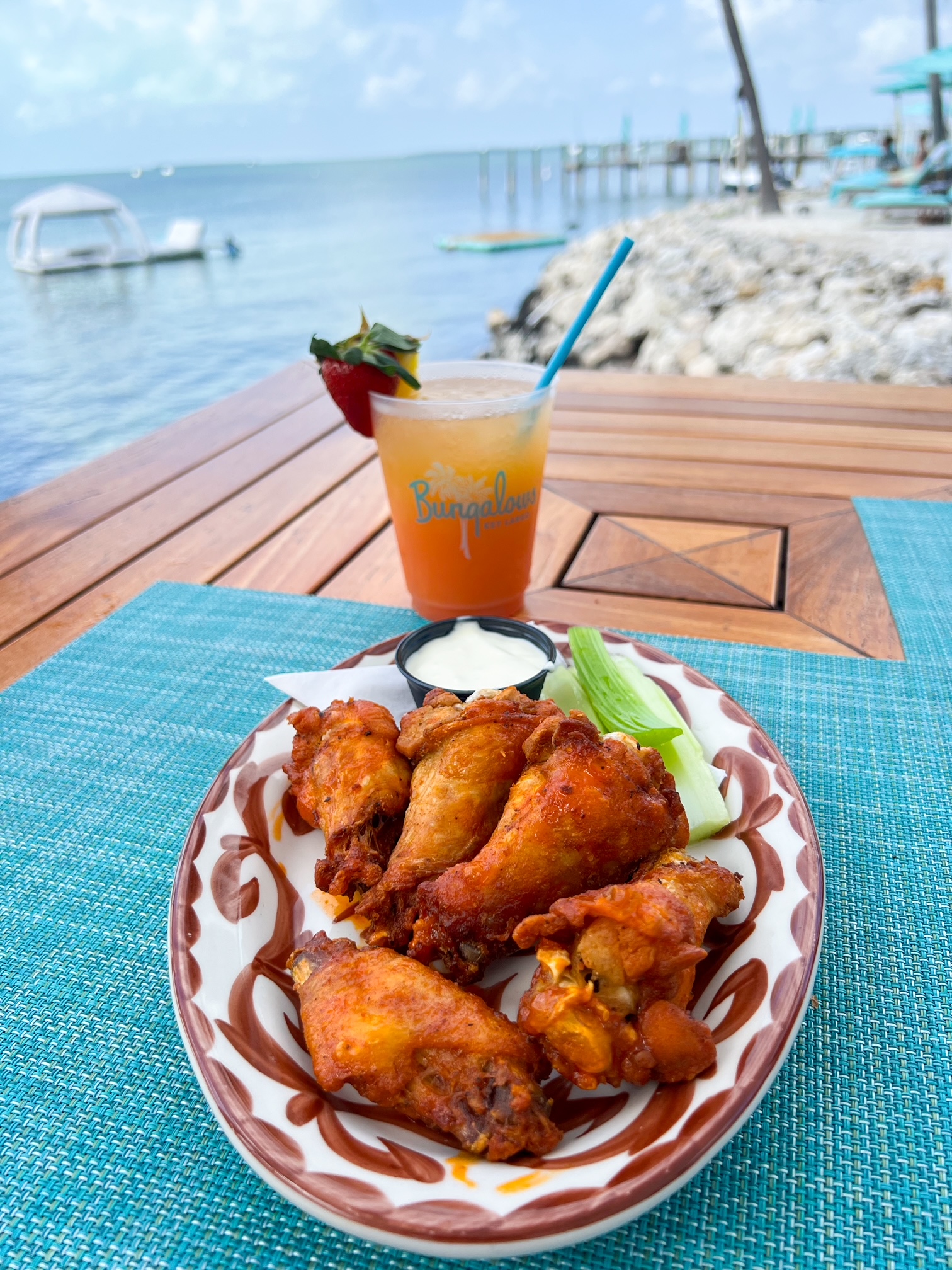 a plate of wings for a snack at the tiki bar overlooking the water