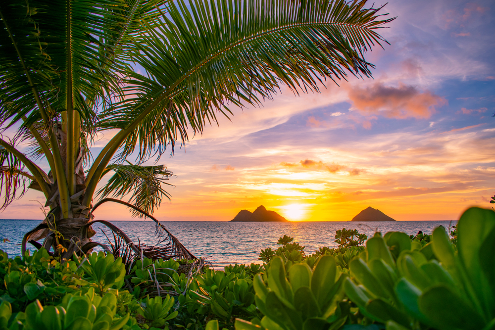 A gorgeous tropical sunrise over Lanikai Beach in Kailua, Oahu, Hawaii. The article is about  Islands USA citizens can visit without a passport. 