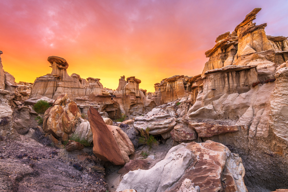 A sunset casts bright orange, yellow and pink over tall rock formations at one of the many national parks in New Mexico, which just so happens to be one of the prettiest states in the USA. 