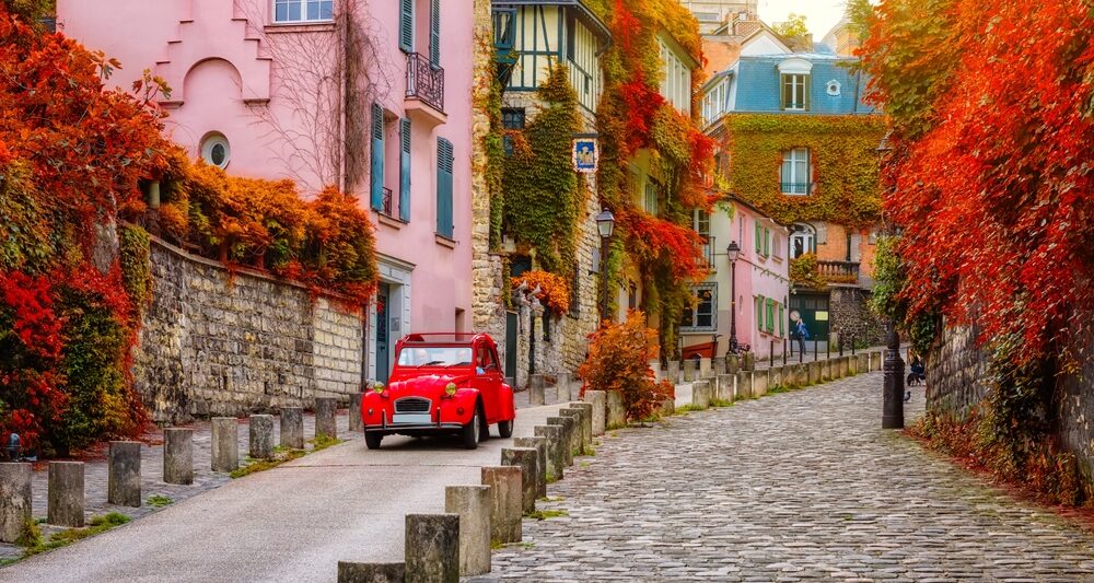 november foliage in paris with pink building and red car