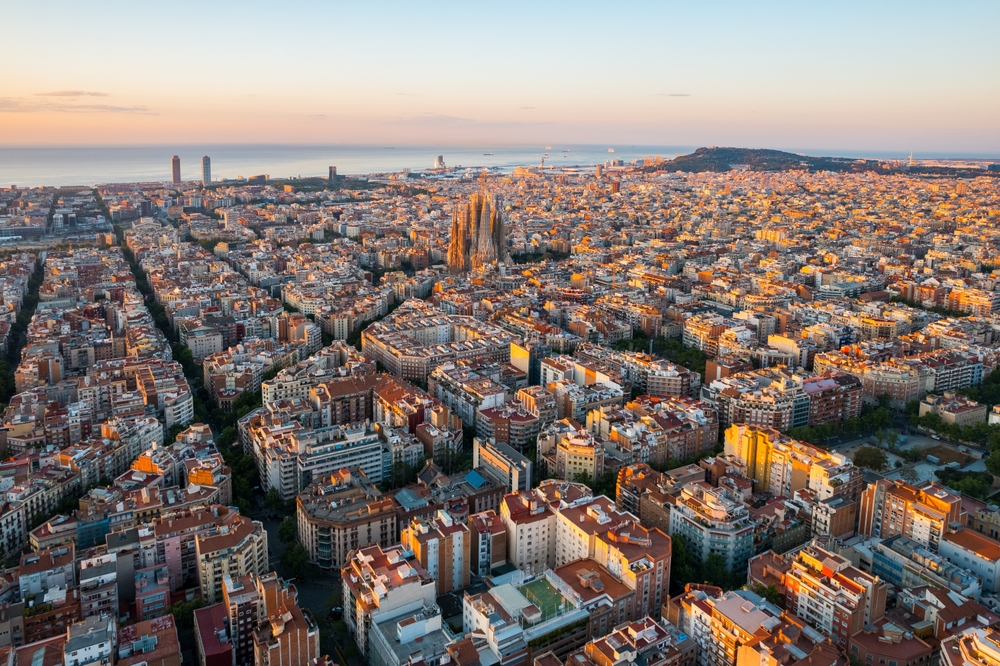 aerial photo of Barcelona streets and buildings, fog in the background at sunrise