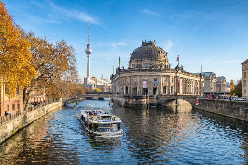 river in berlin in november. a boat is on the water and you can see a tower in the background 