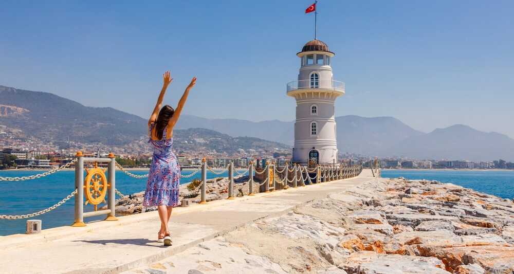 woman standing on a European fort with blue water in the back