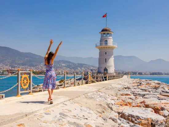 woman standing on a European fort with blue water in the back