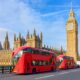 big red bus in london with big ben tower and blue sky