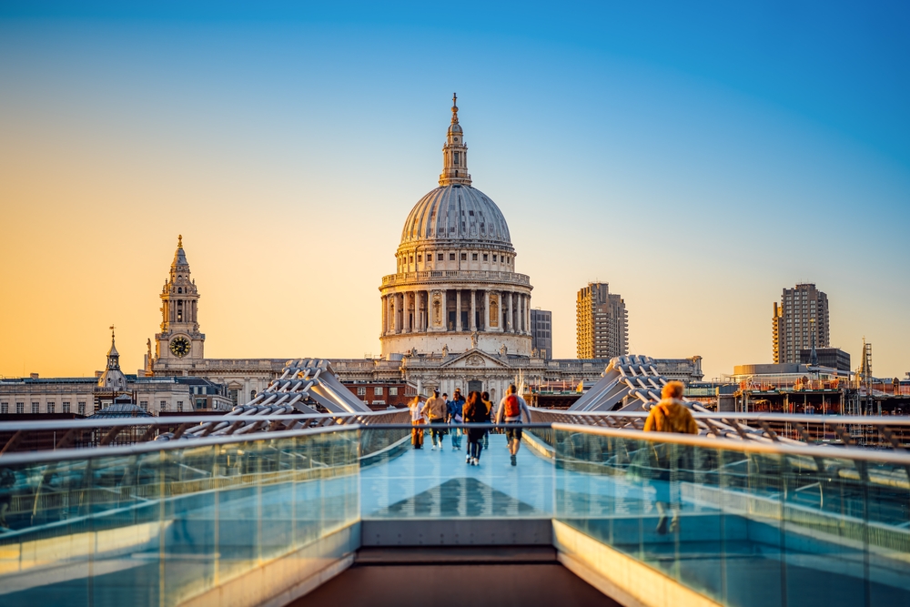 the famous st pauls cathedral of london during sunset from the millennium bridge. 