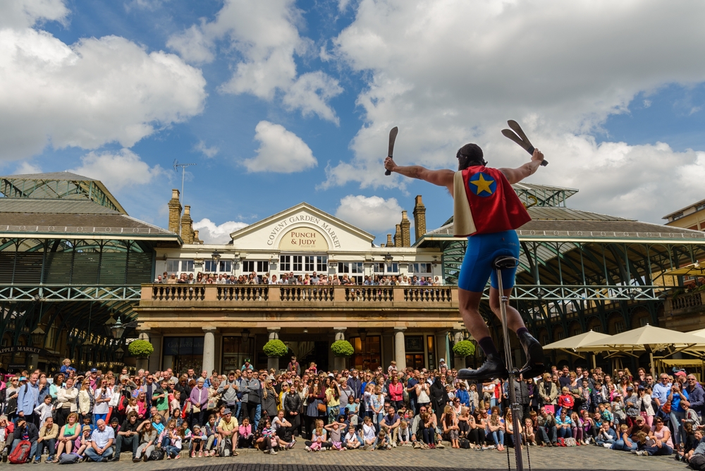 Juggler street entertainer performing in front of crowds of people in Covent Garden. Be aware of pickpockets one of the mistakes to avoid in London