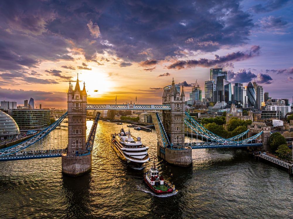 Ship going under Tower Bridge. The bridge is open and the photo is taken at sunset.