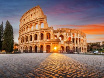 the Colosseum with the sun streaming through one of the front arches