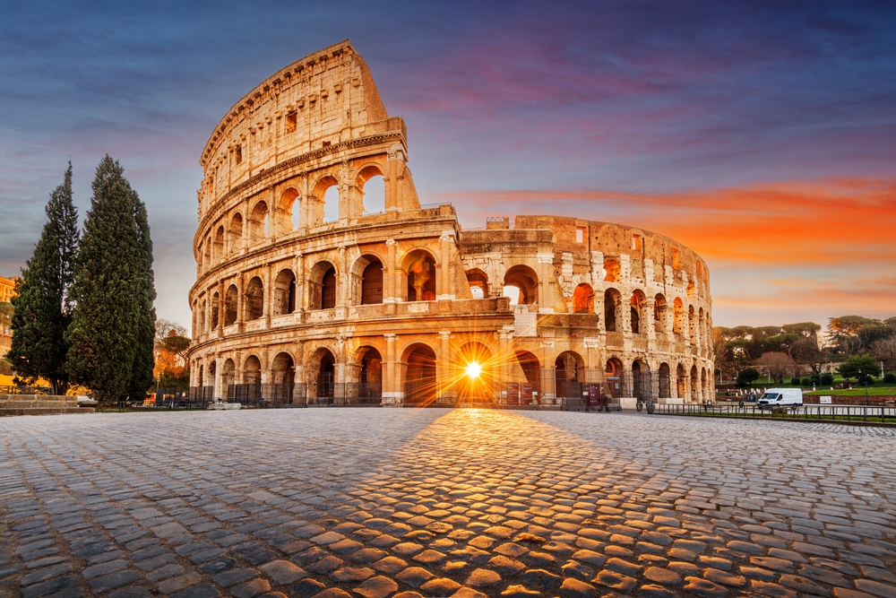 the Colosseum with the sun streaming through one of the front arches