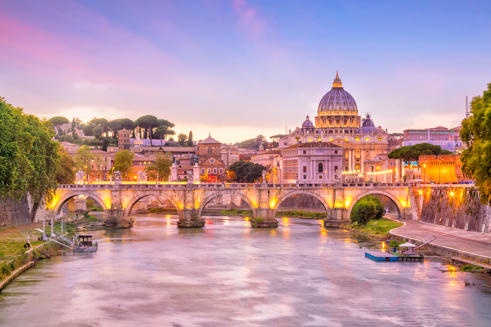 a look at a distance across the water and a bridge of St. Peter's Basilica