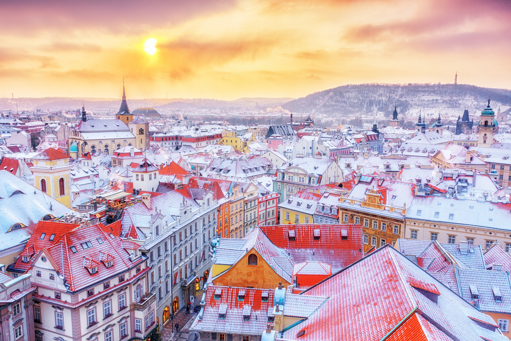 During a nice sunrise, the city of Prague is set aglow with a yellow warmth as snow coats the red-roofed building tops of this wonderful destination. 