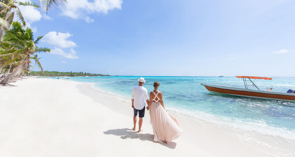 woman and man standing on a beach in the Caribbean on their honeymoon