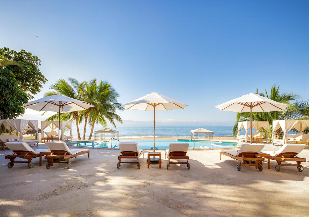 Pool overlooking the ocean with loungers and cabanas. 