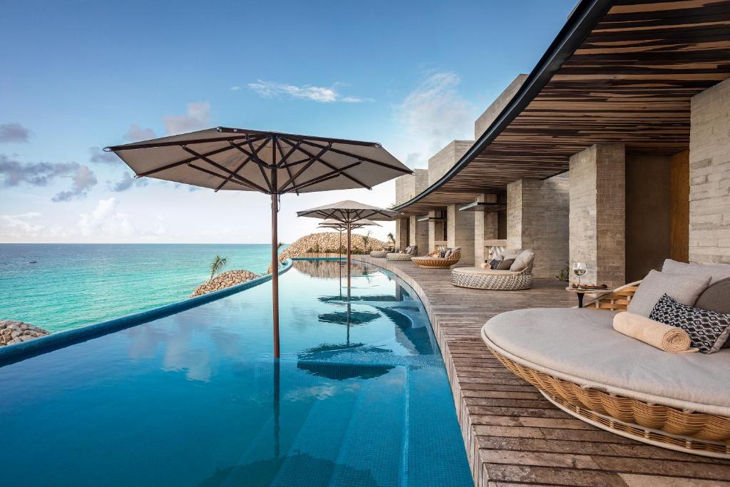 infinity pool looking over the ocean with large day beds along the side. 