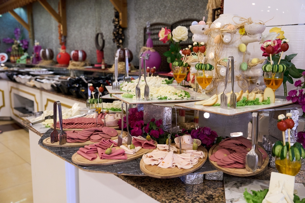 A huge line up of food, buffet style, shows the  all inclusives vs cruises approach to meals: this buffet features a variety of cheeses, meats, cocktails and more. 