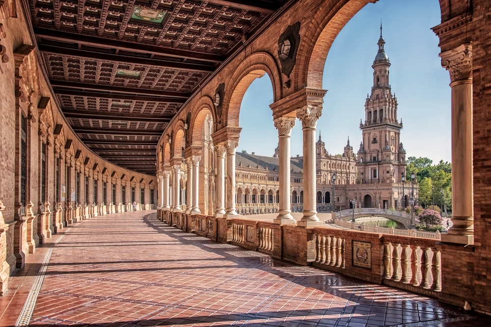 curved walkway that leads to a church and has curved columns on both side of it 